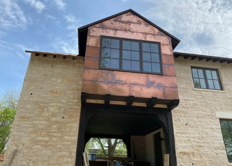 Copper metal panel facade on a stone building for Roof Repair in Bellevue